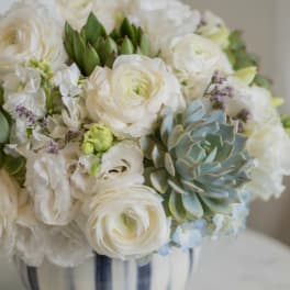 White floral arrangement in a silver vase with a blue-green succulent