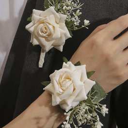 White rose corsage and boutonniere with small white filler flowers