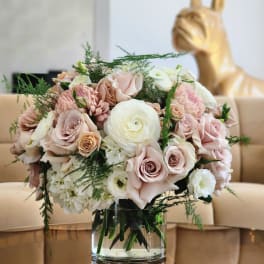 Blush and white flower bouquet in a clear glass vase