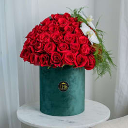 Large bouquet of red roses in a green velvet box with white orchids