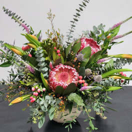 Large mixed bouquet with pink protea and yellow lilies in a vase