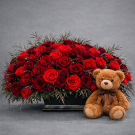 Red rose arrangement with a teddy bear