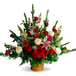 Basket arrangement of red roses, pink lilies, and white mums