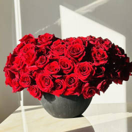 Red rose bouquet in a dark round vase