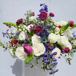 Bouquet of white, pink, and purple flowers in a clear vase