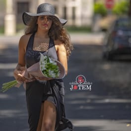 Woman holding a bouquet of white flowers wrapped in pink paper