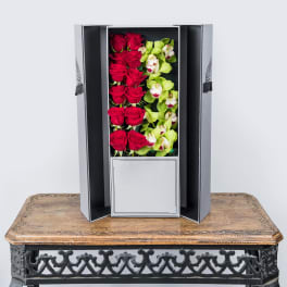 Boxed arrangement of red roses and green orchids