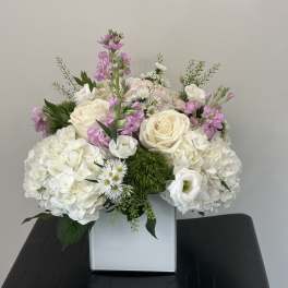 White and pink floral arrangement in a square vase