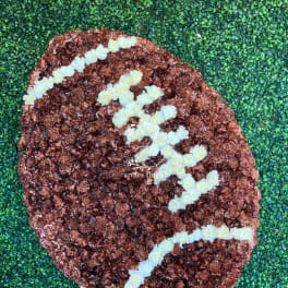 Football-shaped floral display on a wooden easel