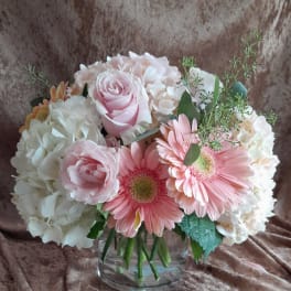 Pink roses and gerbera daisies in a clear glass vase