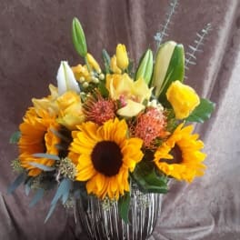 Sunflower and lily bouquet in a striped glass vase