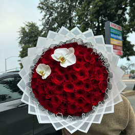 Large round bouquet of red roses with two white orchids