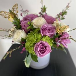 Pink and white roses arranged in a white vase
