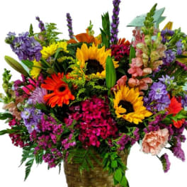 Colorful mixed flower arrangement in a woven basket