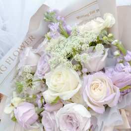 Bouquet of pale lavender and white roses with airy filler flowers