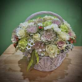 Basket arrangement of cream roses and small white daisies