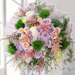 Bouquet of lavender and peach roses with green pom-pom accents