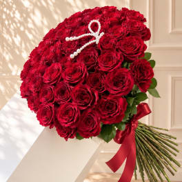 Large bouquet of red roses with a pearl ribbon and red satin bow