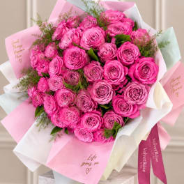 Bouquet of bright pink roses wrapped in pink and white paper