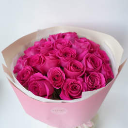 Bouquet of bright pink roses wrapped in pink paper