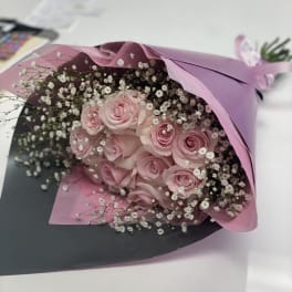 Bouquet of pink roses with white baby's breath in pink and black wrap