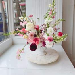 Pink and white mixed flower arrangement in a white vase