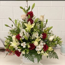 Red and white floral basket with lilies and roses
