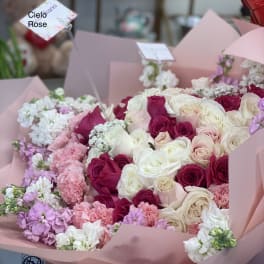 Pink and white rose bouquets with carnations in pastel wrapping