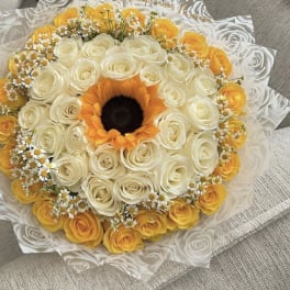 Round bouquet of white and yellow roses with a sunflower center