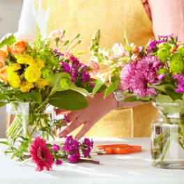 Two colorful flower bouquets in glass vases on a table
