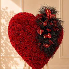 Heart-shaped red rose arrangement on a wooden stand
