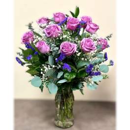 Bouquet of pink roses and purple filler flowers in a glass vase