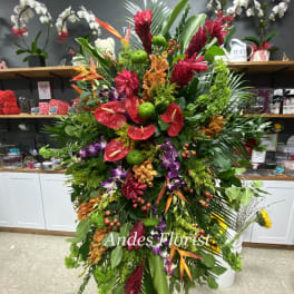 Large tropical floral standing spray with red, orange, purple, and green blooms