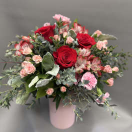 Pink and red rose bouquet in a pale pink vase