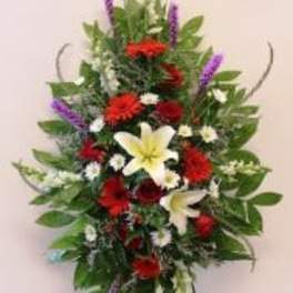 Standing floral spray with red, white, yellow, and purple flowers