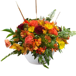Autumn bouquet of orange roses and yellow daisies in a white bowl vase