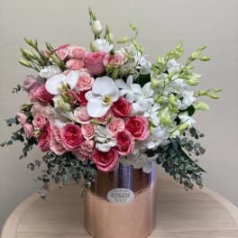 Pink and white floral arrangement in a metallic vase