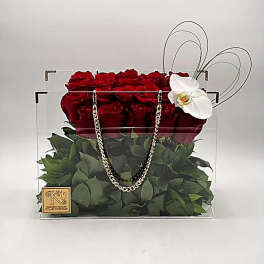 Red roses in a clear square box with a white orchid accent
