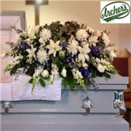Large white and purple funeral spray on a casket