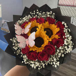 Bouquet of red roses and sunflowers with pink butterfly decorations