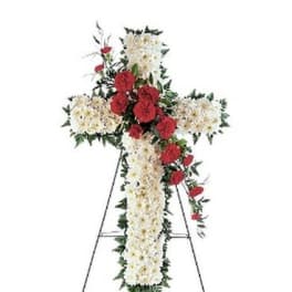 Standing floral cross with white and red flowers on an easel