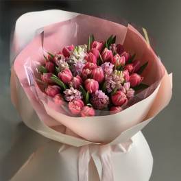 Pink tulip bouquet wrapped in pale pink paper with a ribbon