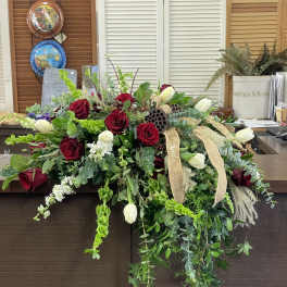 Large floral arrangement with red roses, white tulips, and trailing greenery