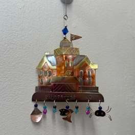 Metal wall hanging shaped like a house with dangling beads and charms