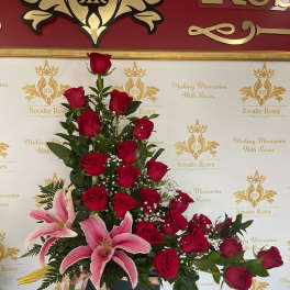 Tall arrangement of red roses and pink lilies in a black box