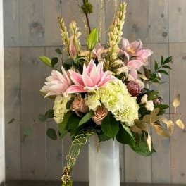 Tall pink and cream floral arrangement in a white vase