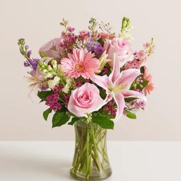 Pink roses and lilies in a clear glass vase