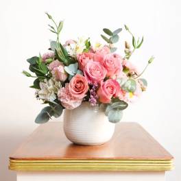 Pink rose bouquet in a white ceramic vase