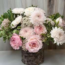 Pink and white roses with white chrysanthemums in a rustic vase