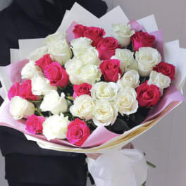 Bouquet of pink and white roses wrapped in pastel paper
